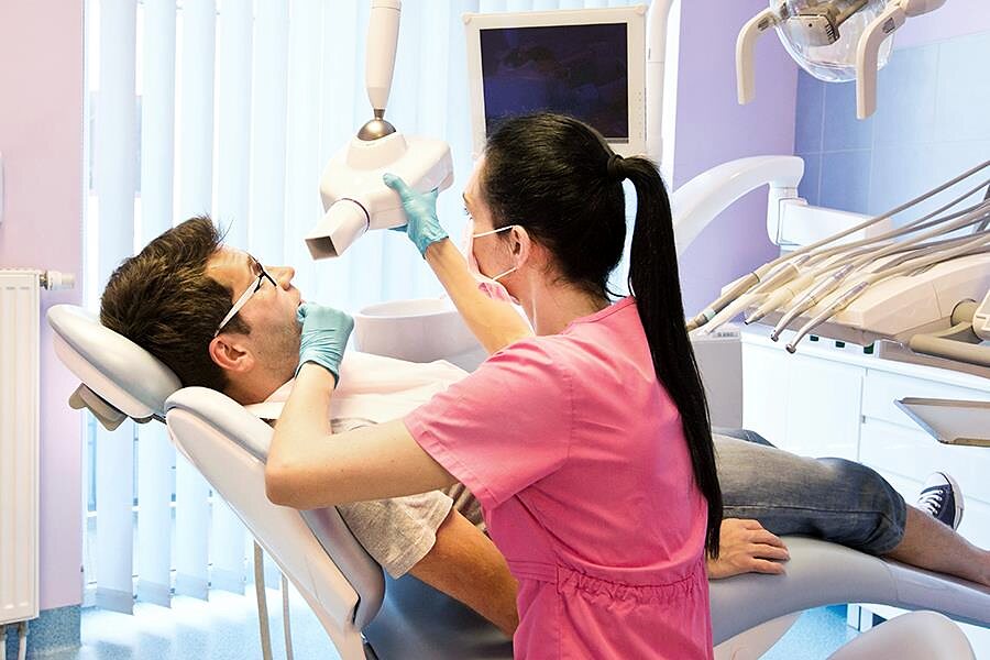Wykonywanie punktowego zdjęcia rentgenowskiego przy fotelu stomatologicznym